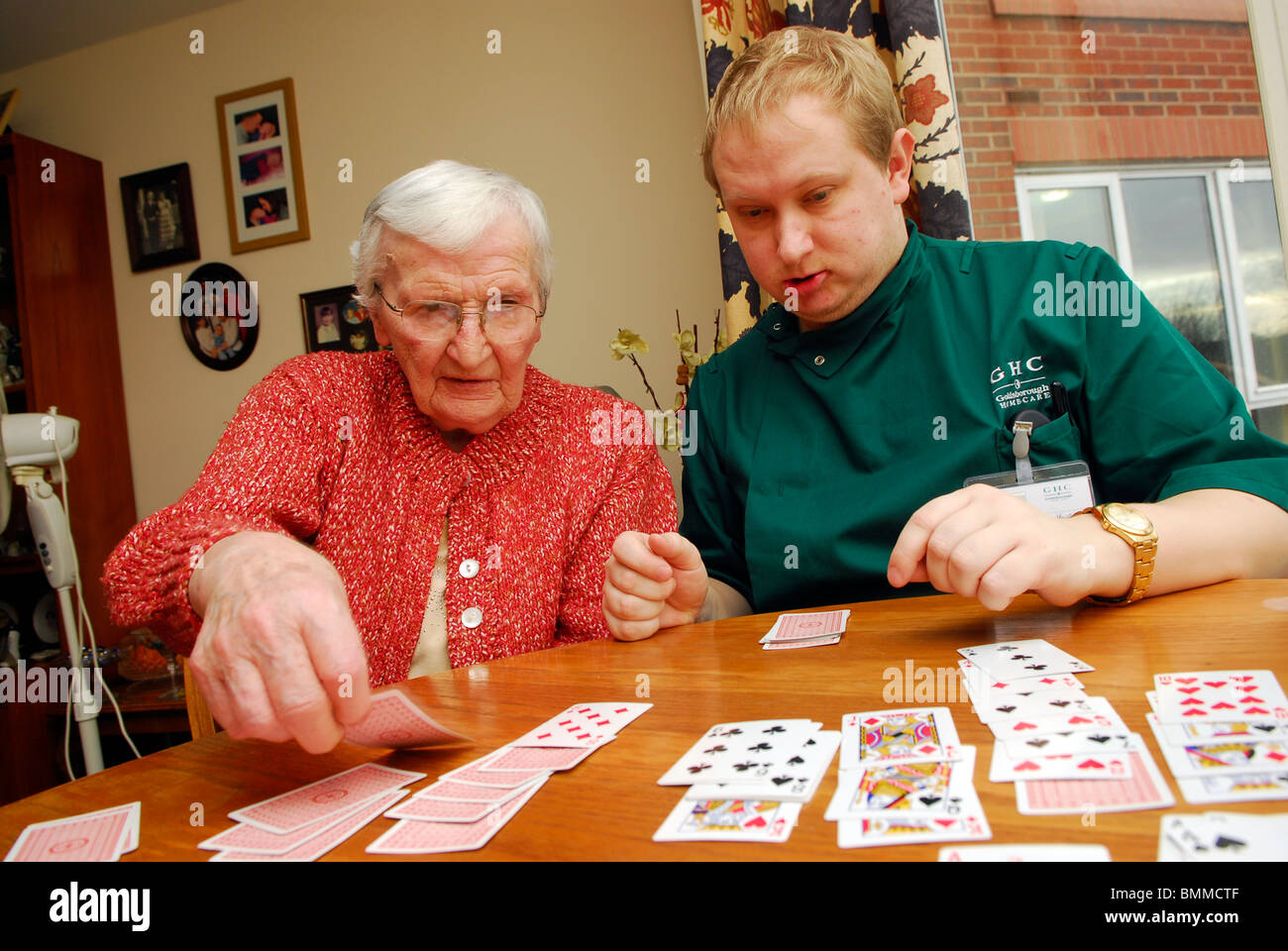 Care worker playing cards with an elderly lady in residential care home, Wirral, UK. Stock Photo