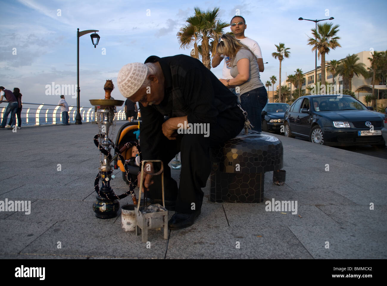 a Muslim man preparing his Nargila on the cornice of Beirut Lebanon Stock Photo