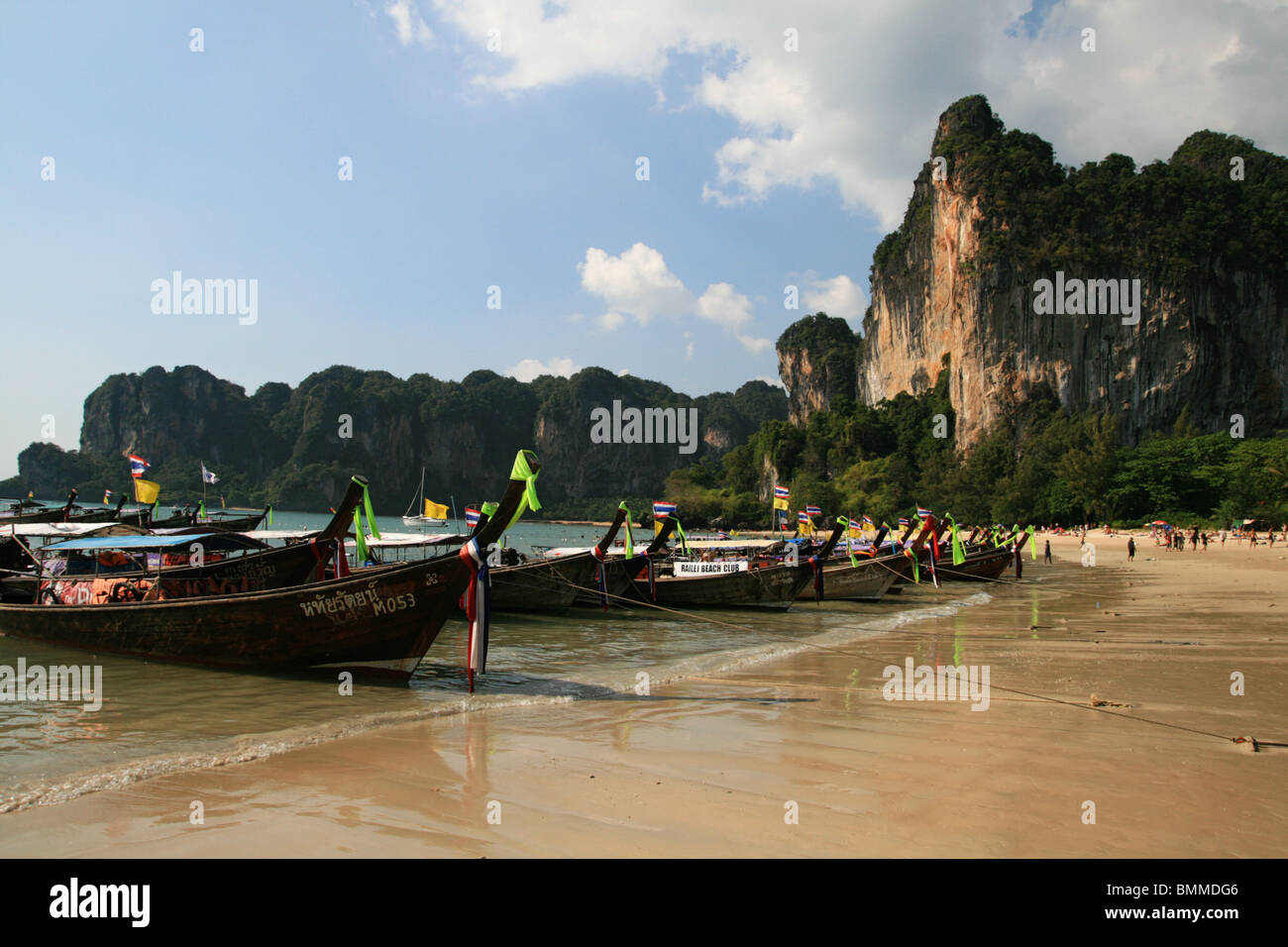 long tail boats on west Railay Beach, Tonsai, with cliff behind Stock Photo