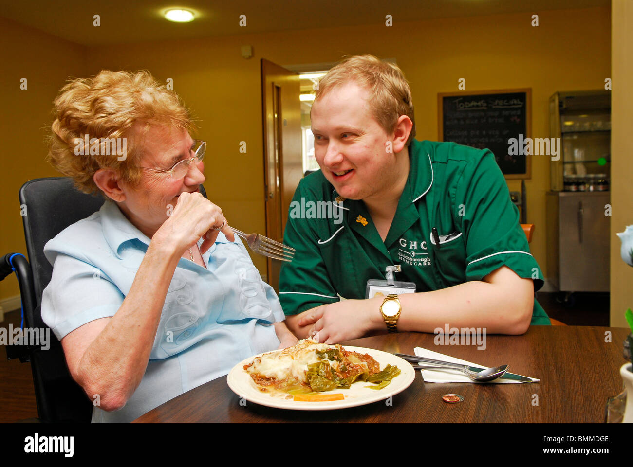 Healthcare worker chatting to an elderly resident at an old people's home, Wirral, UK. Stock Photo