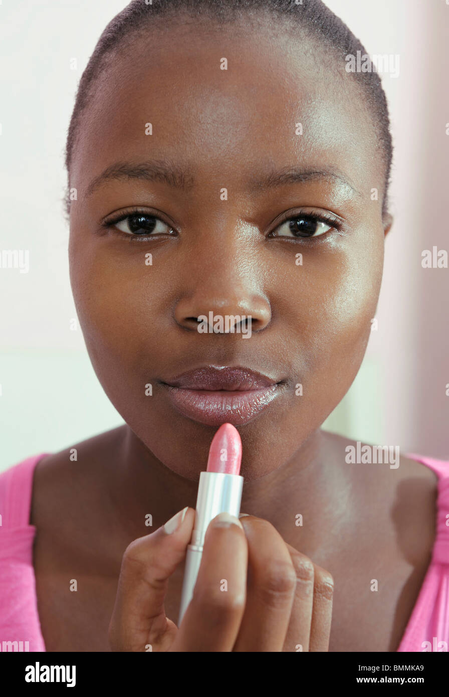 Teenage girl applying pink lipstick, Cape Town, Western Cape Province, South Africa Stock Photo