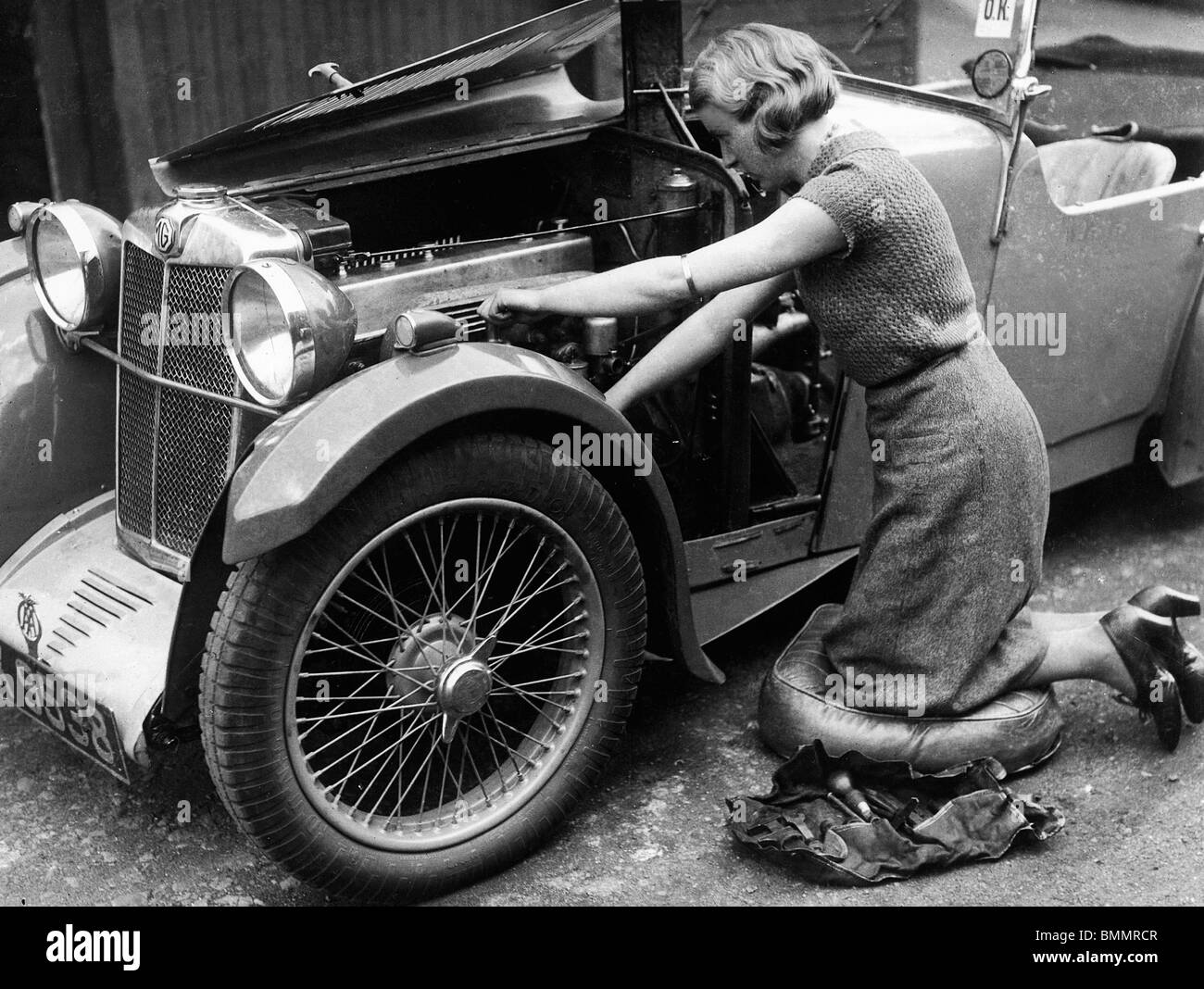 MG F type Midget with driver Kitty Brunell servicing engine 1930's Stock Photo