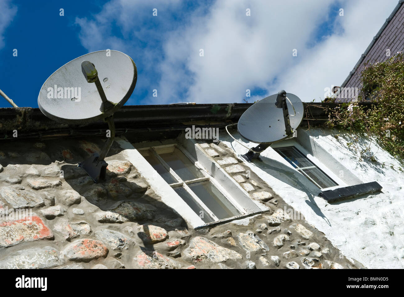 Television satellite dishes on exterior wall of cottages in Llanwrtyd