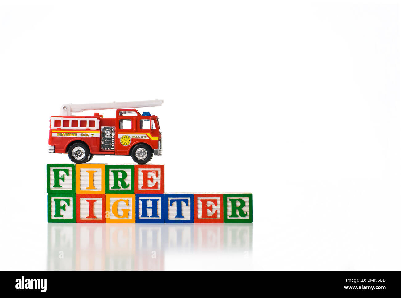Colorful children's blocks spelling FIREFIGHTER with a toy fire truck Stock Photo
