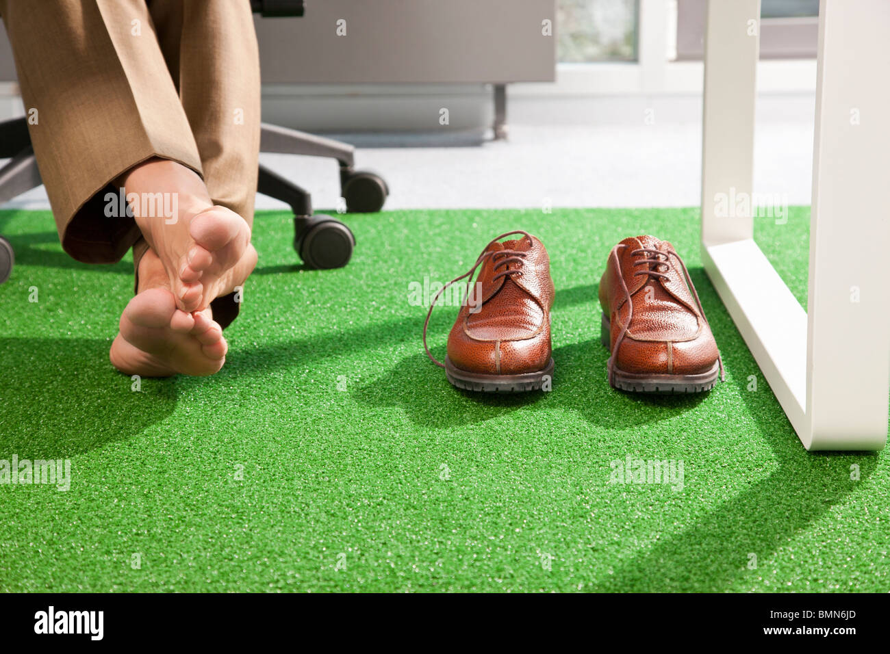 Relaxed feet on a green office carpet Stock Photo Alamy