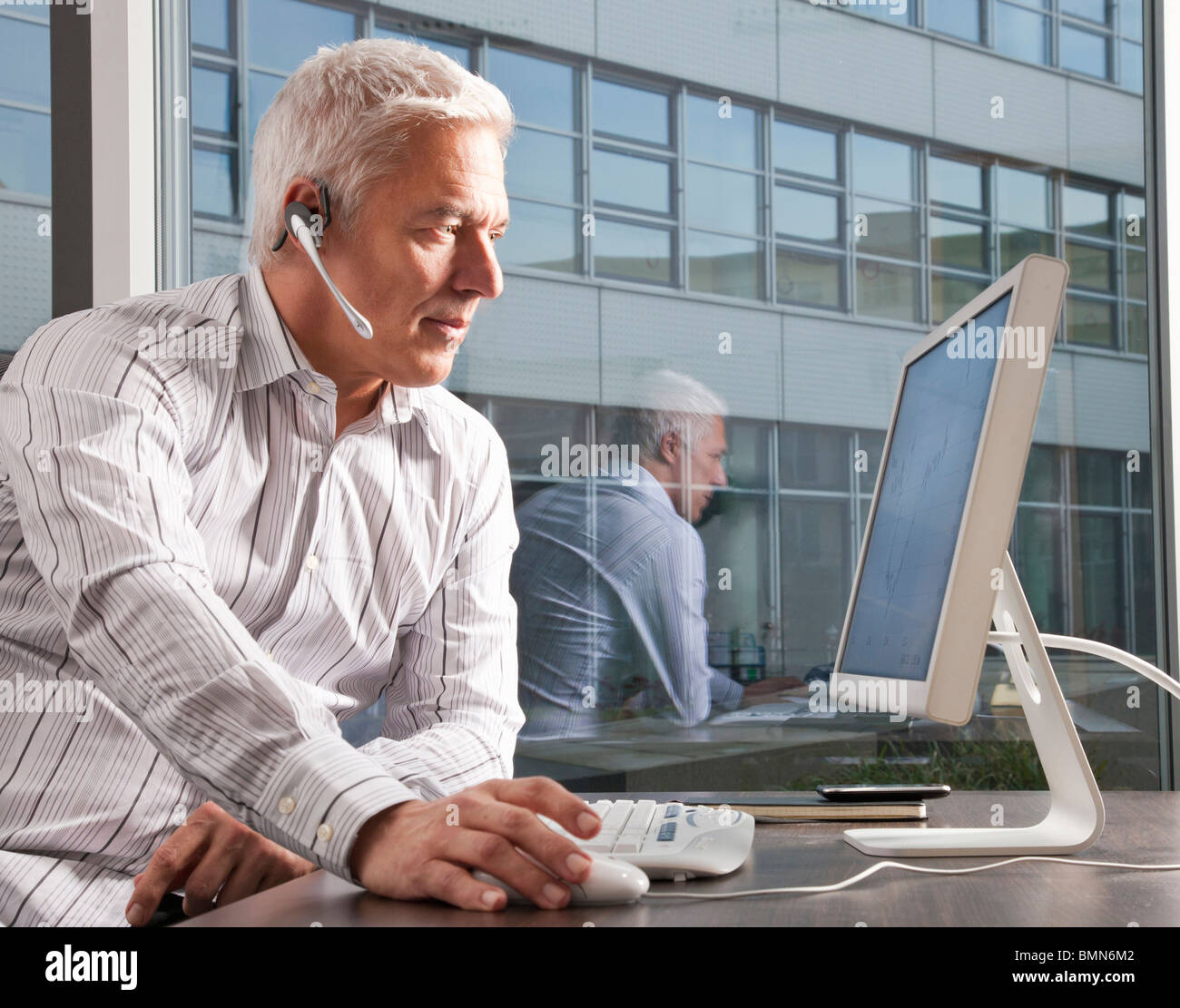 Man with headset working on computer Stock Photo