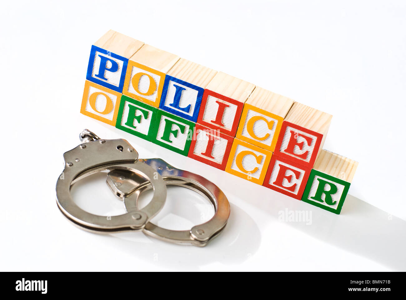 Colorful children's blocks spelling POLICE OFFICER with hand cuffs Stock Photo