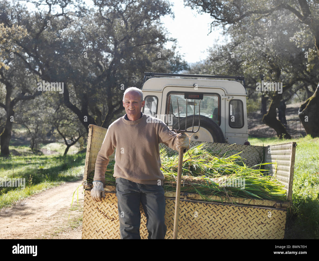 Farmer standing in front of trailer Stock Photo