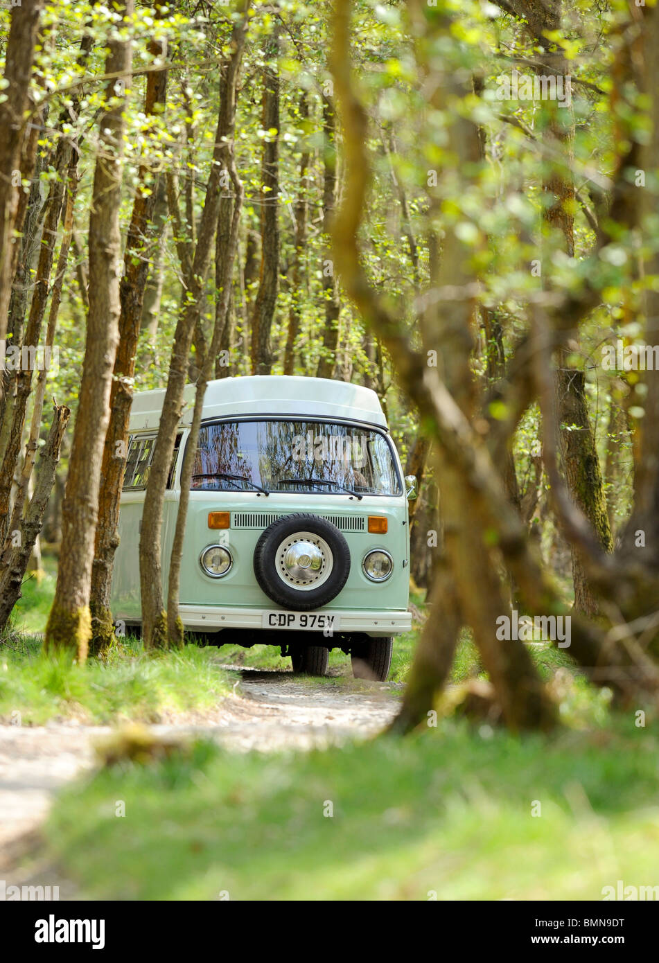 A young couple enjoying a camping holiday in a classic VW campervan. Stock Photo