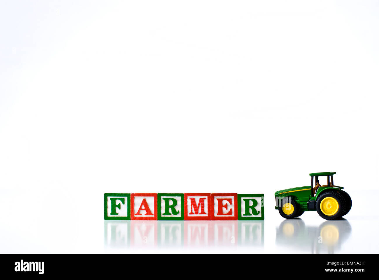Colorful children's blocks spelling FARMER with a tractor Stock Photo