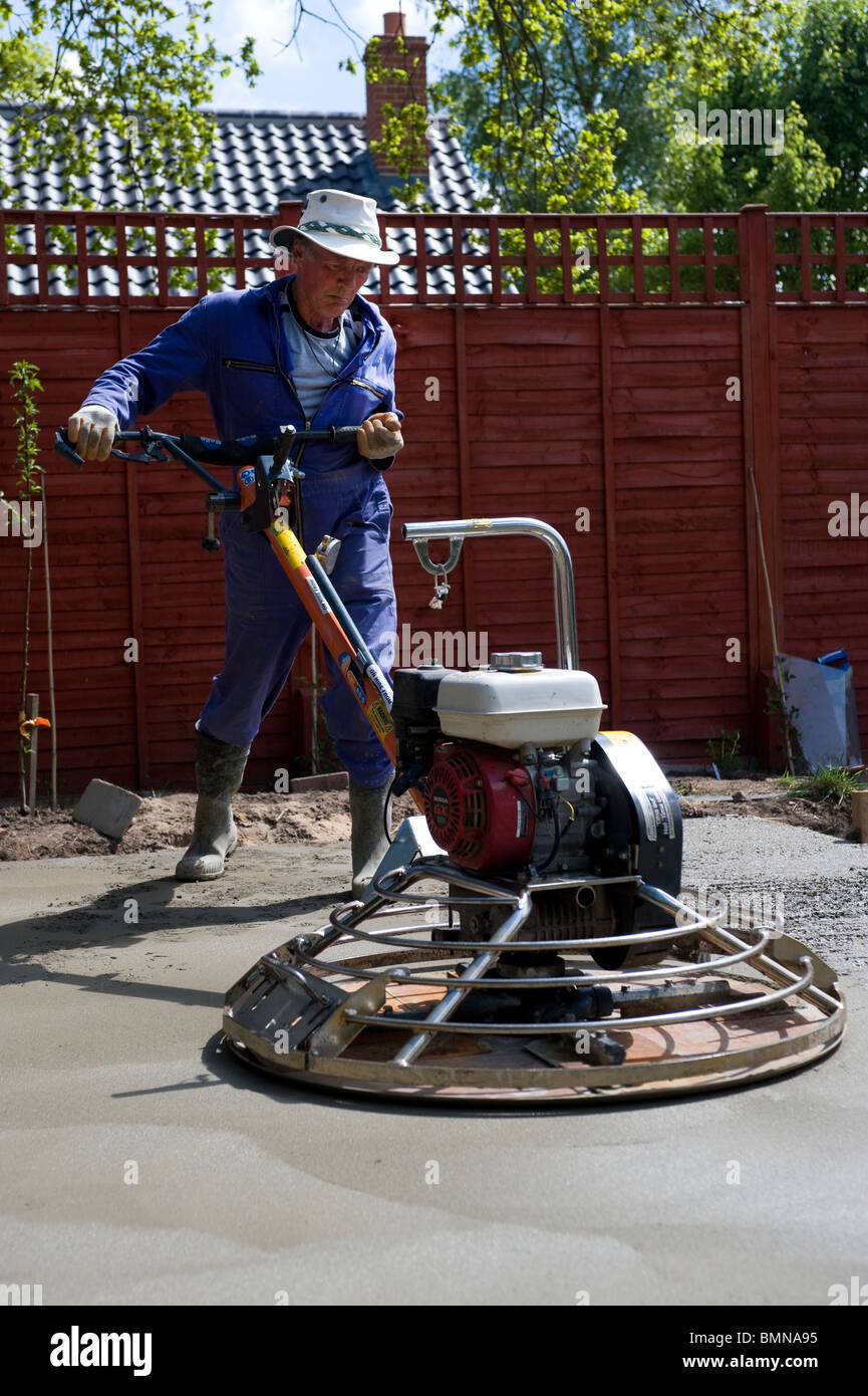 man leveling concrete base with power float Stock Photo Alamy