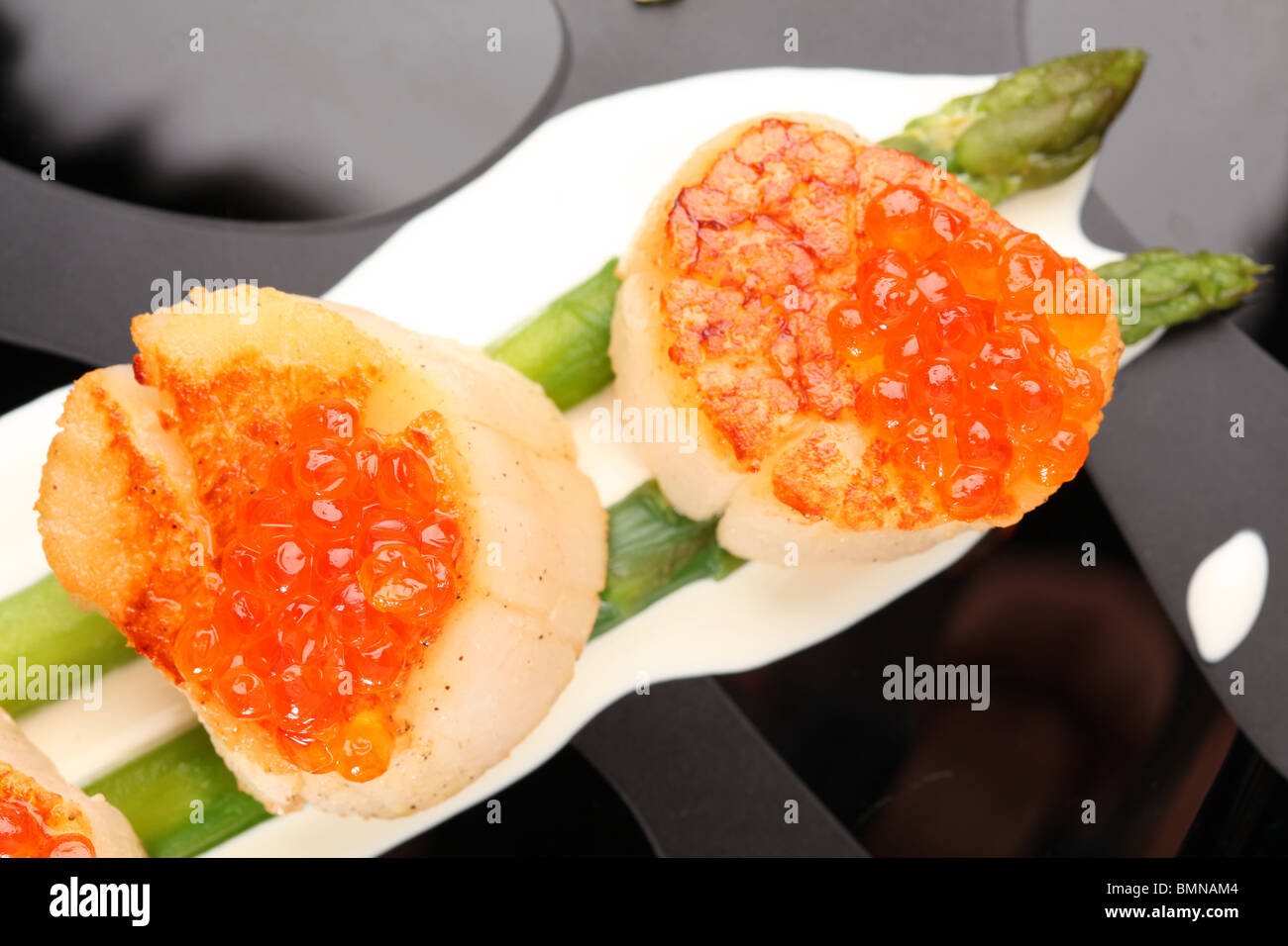 Grilled sea scallops with asparagus in a black plate Stock Photo Alamy