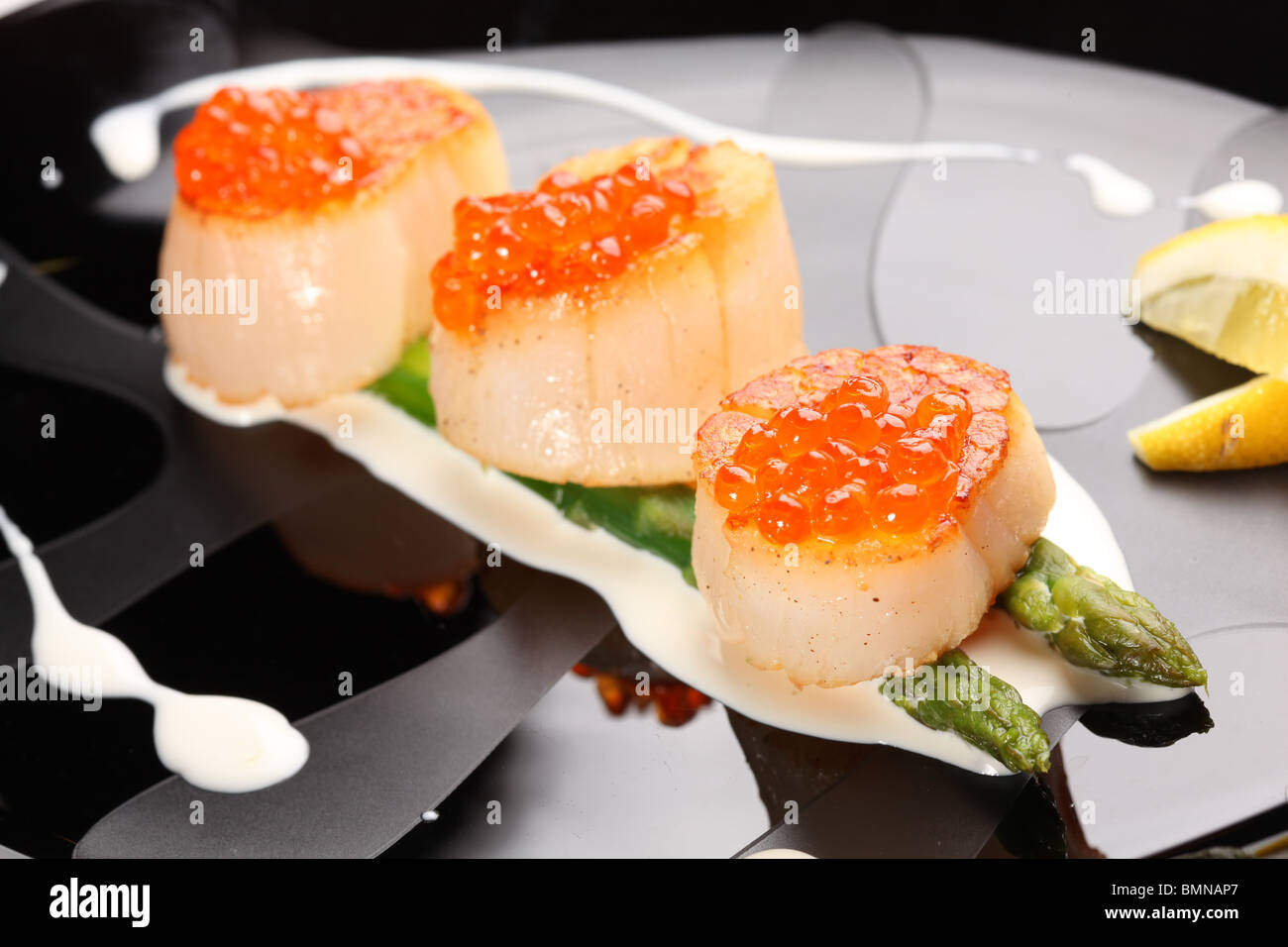 Grilled sea scallops with asparagus in a black plate Stock Photo Alamy