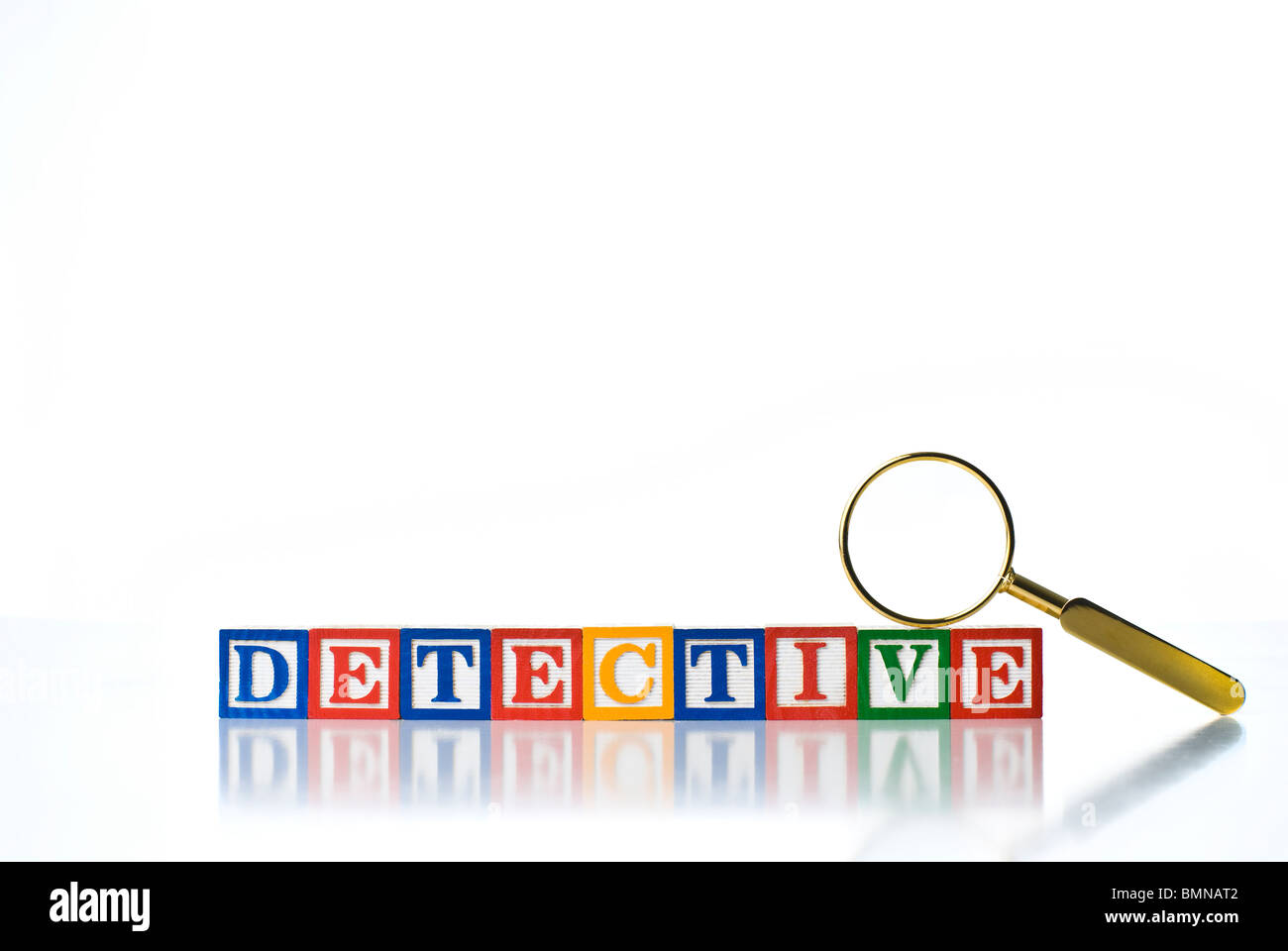 Colorful children's blocks spelling DETECTIVE with a magnifying glass