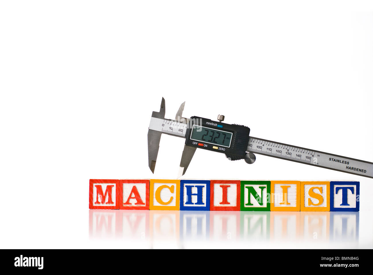 Colorful children's blocks spelling MACHINIST with digital calipers