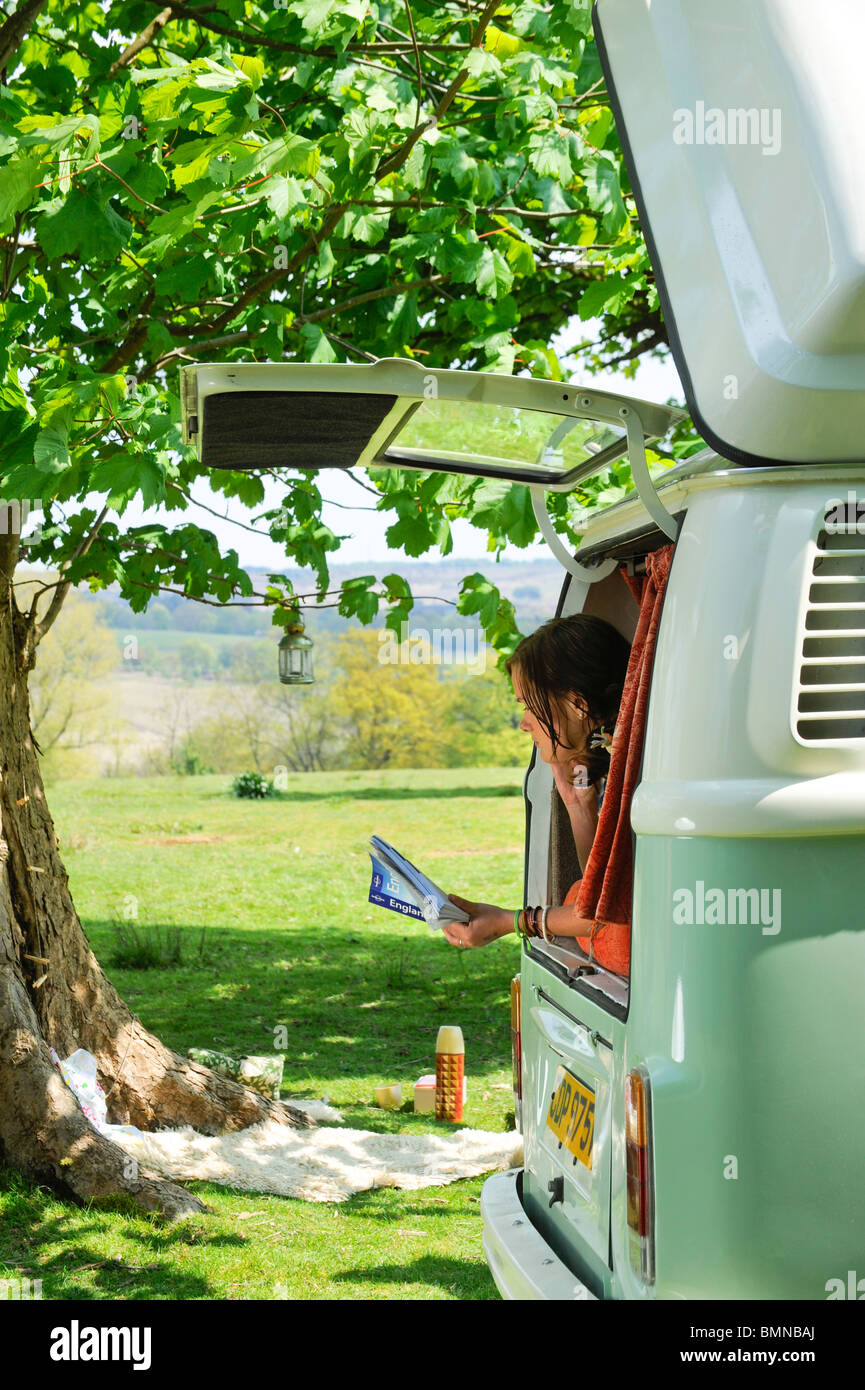 A young couple enjoying a camping holiday in a classic VW campervan. Stock Photo