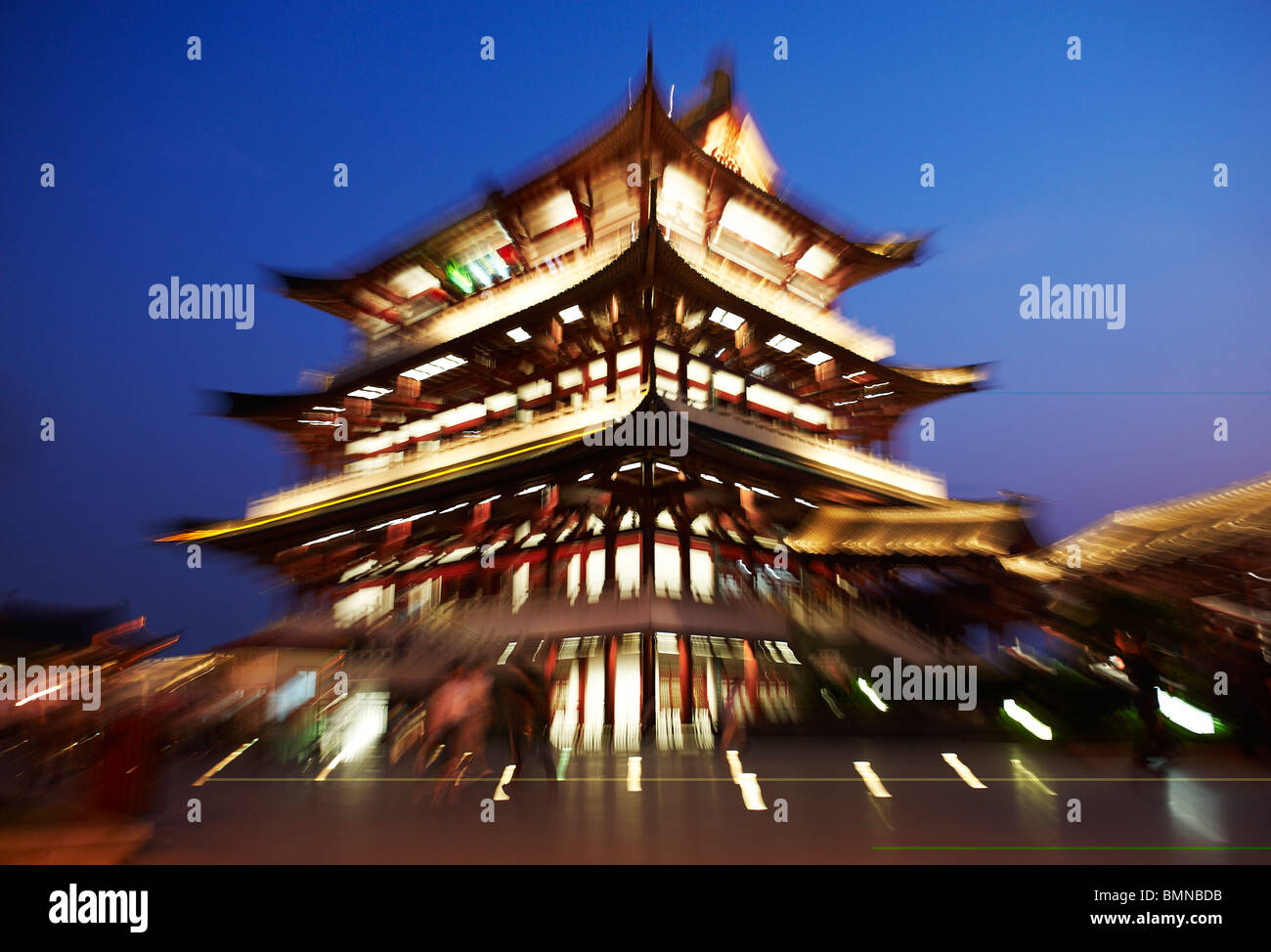A traditional Chinese style building photographed at twilight with lens zoomed in. Against rich blue sky with yellow light trail Stock Photo