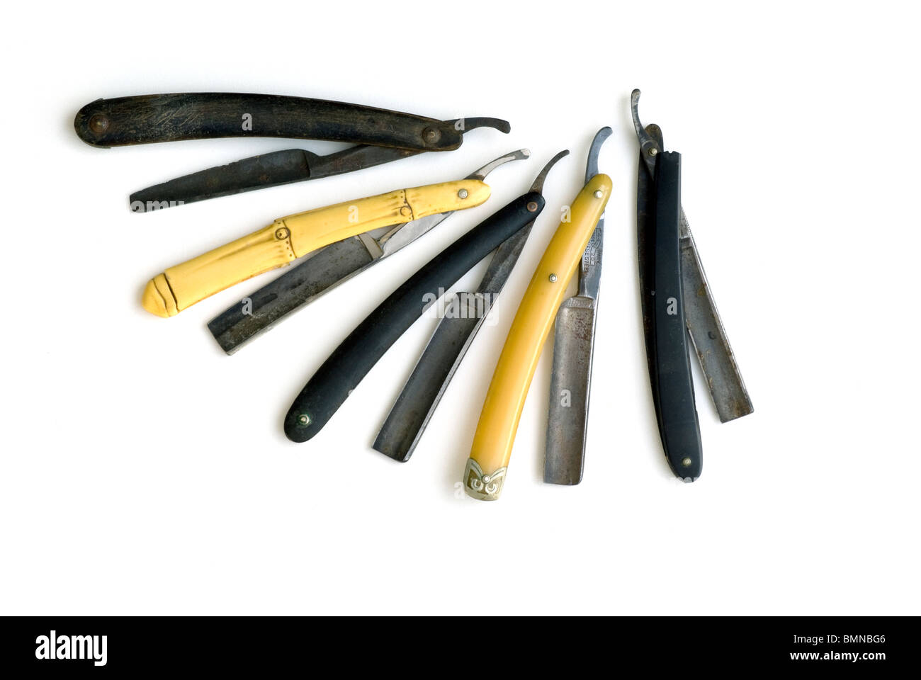 5 antique straightedge razors on white background. A closeup display