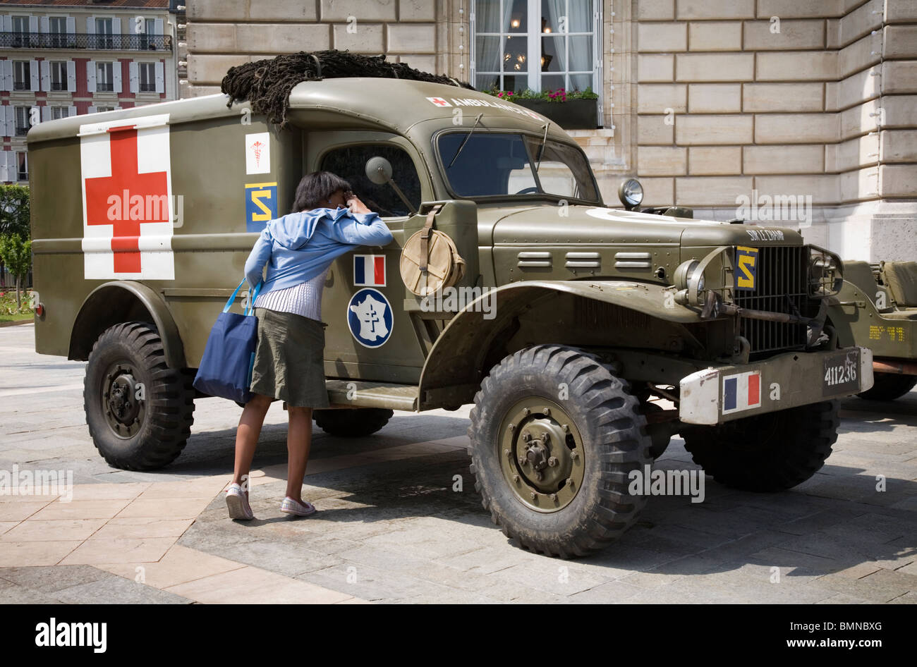 A woman checking a WW2 vintage Ambulance, Paris Stock Photo