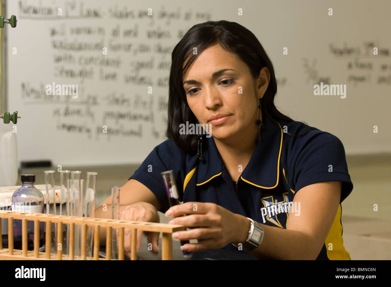 Female biology teacher examines test tubes in her classroom at Hidalgo Early College High School in Hidalgo, Texas. Stock Photo