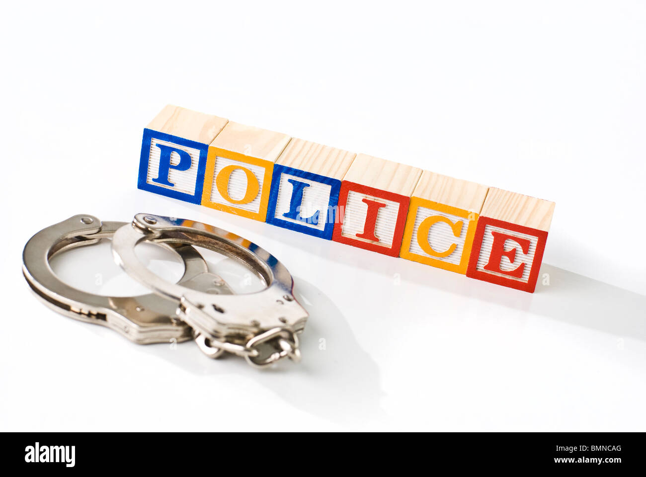 Colorful children's blocks spelling POLICE with hand cuffs Stock Photo