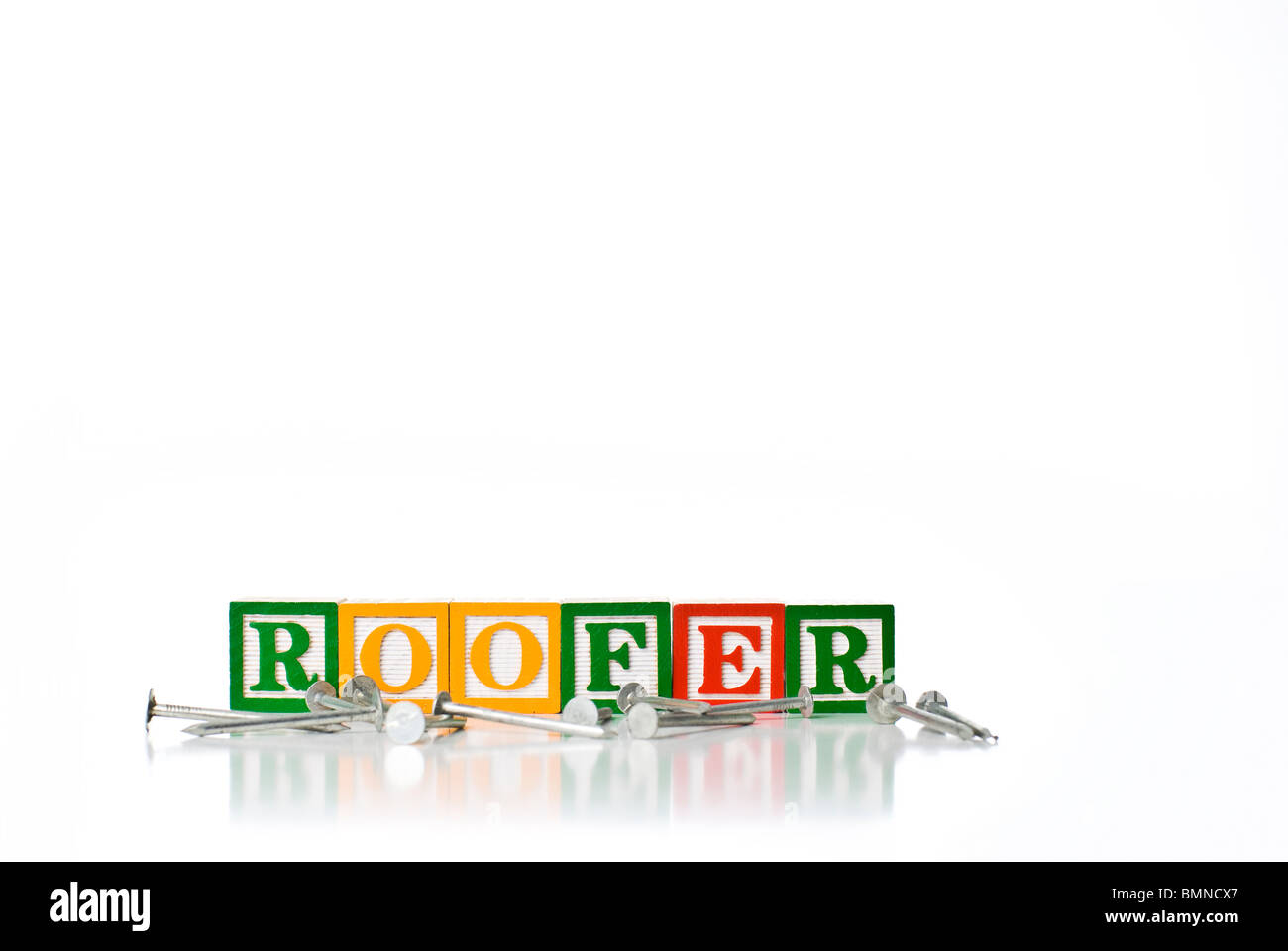 Colorful children's blocks spelling ROOFER with roofing nails Stock Photo