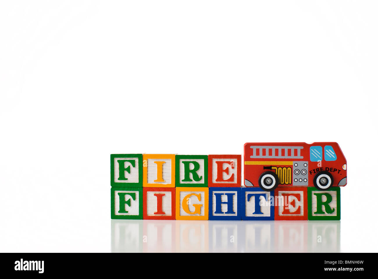 Colorful children's blocks spelling FIREFIGHTER with a toy fire truck Stock Photo