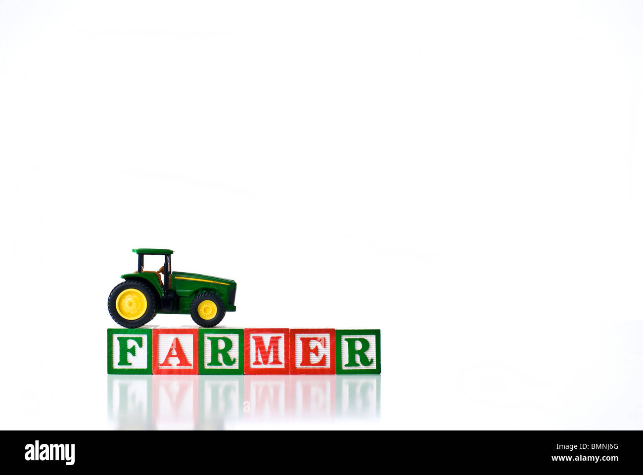 Colorful children's blocks spelling FARMER with a tractor Stock Photo