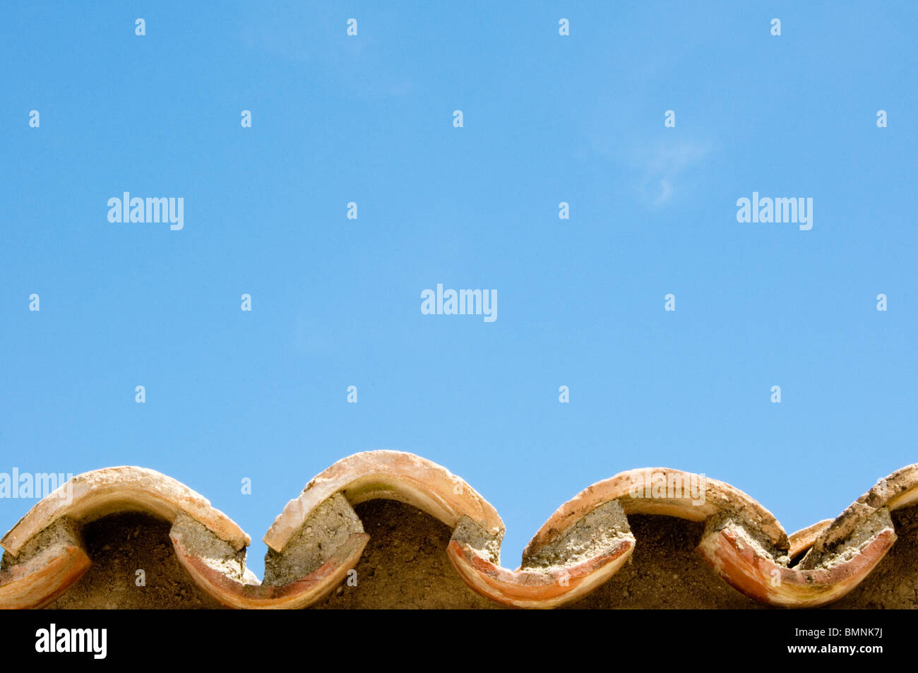 Clay roof tiles against a bright blue sky Stock Photo