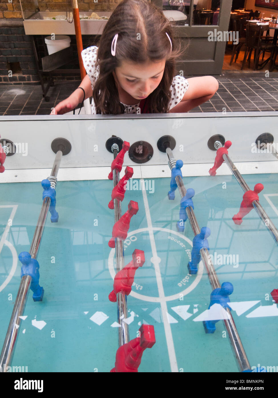 Little girl playing tabletop football Stock Photo - Alamy