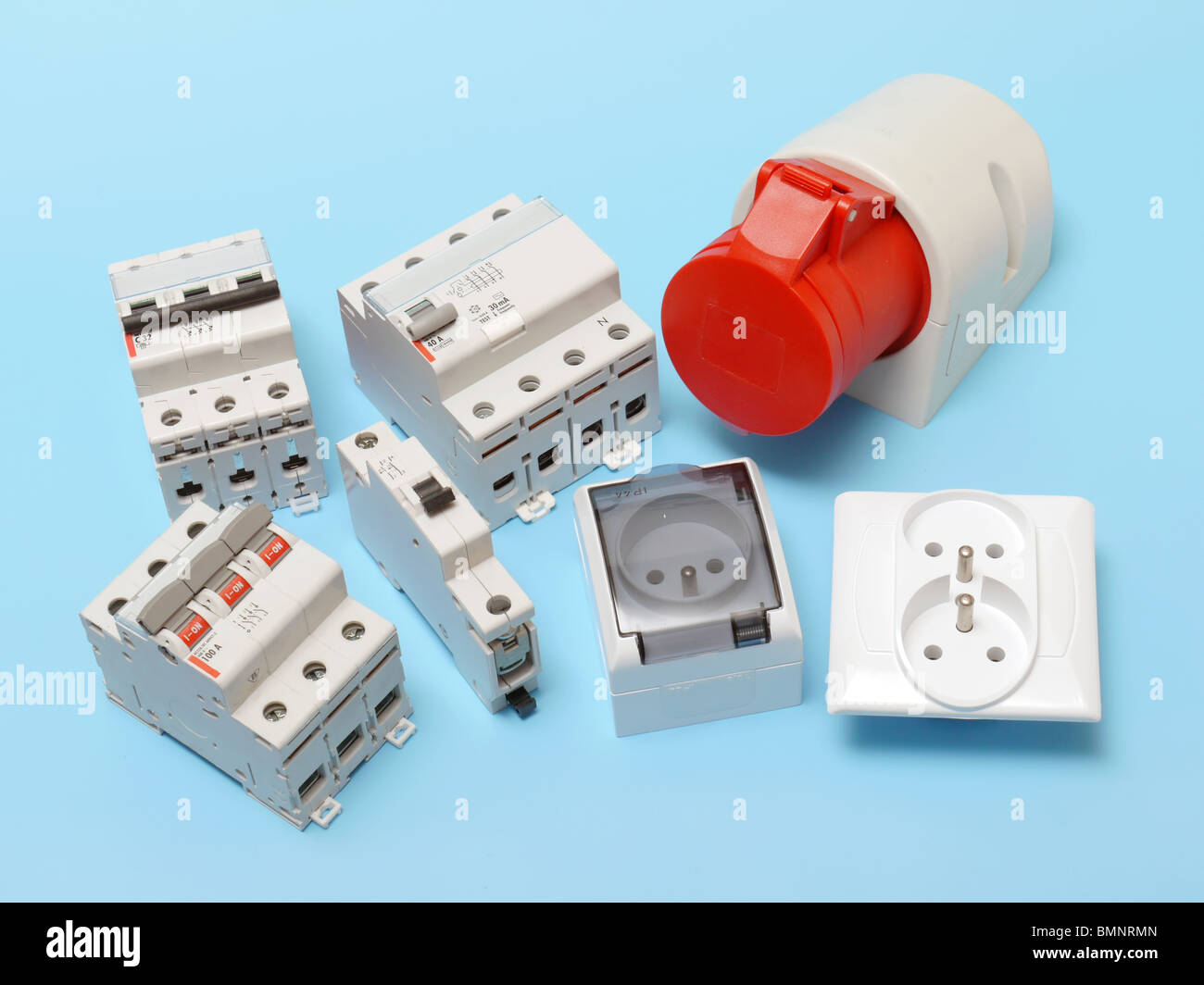 Electrical circuit breakers, main disconnect, power socket and 230 Volt wall sockets shot over blue Stock Photo