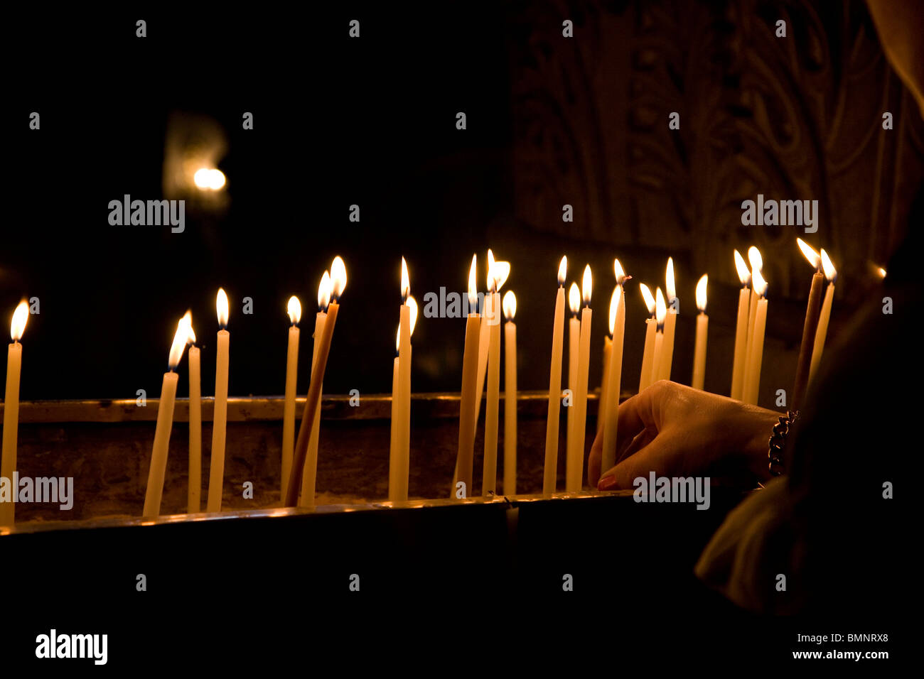 Lighting candles at church of The Holy Sepulchre in Jerusalem Stock