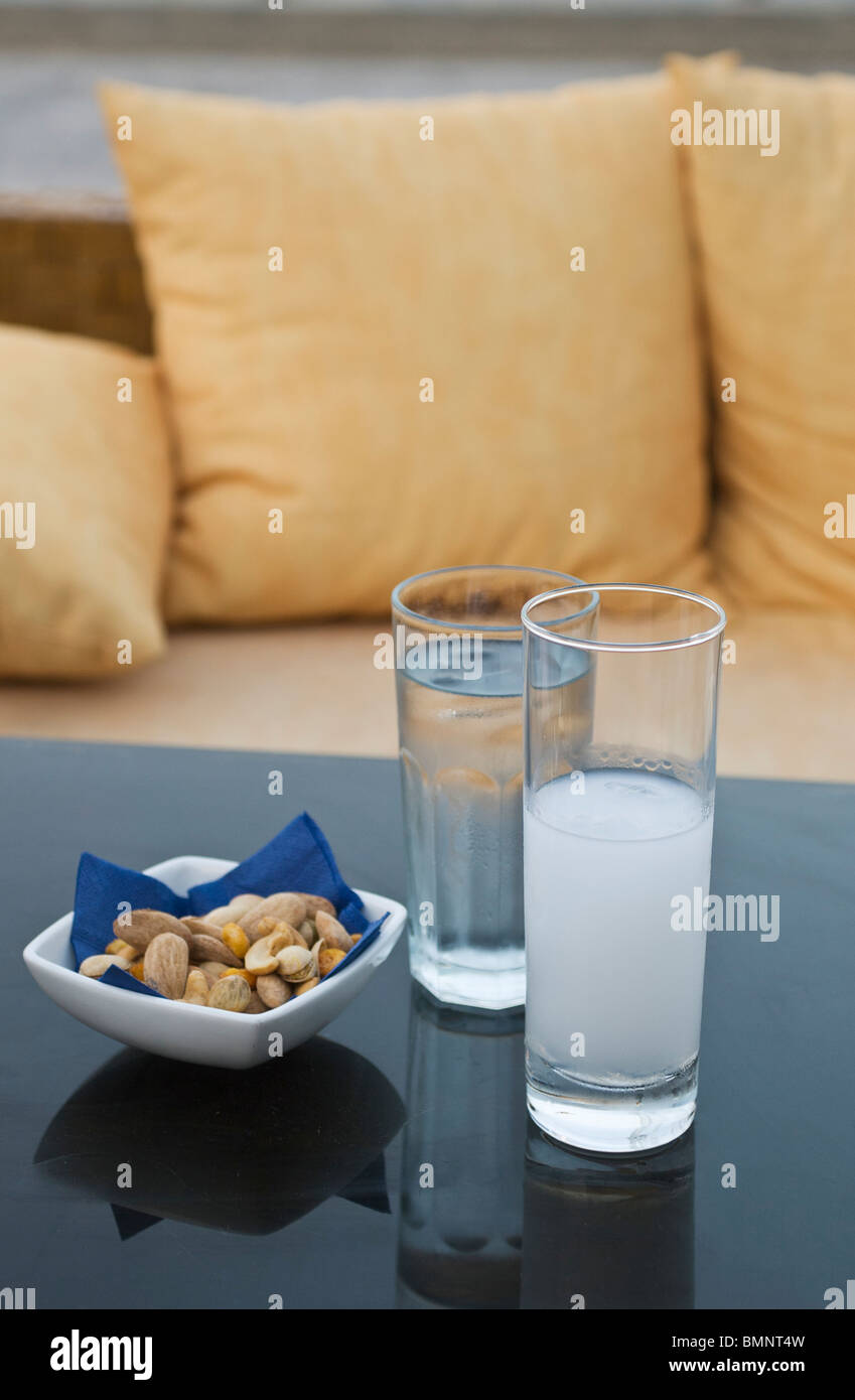 Glass of Ouzo, water and snacks on a cafe table in Skopelos, Greece Stock Photo