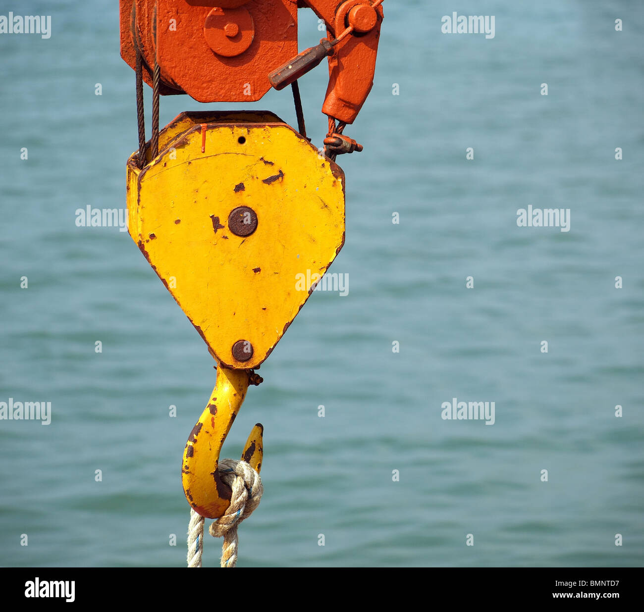 A strong yellow painted hook of a small boat crane Stock Photo Alamy