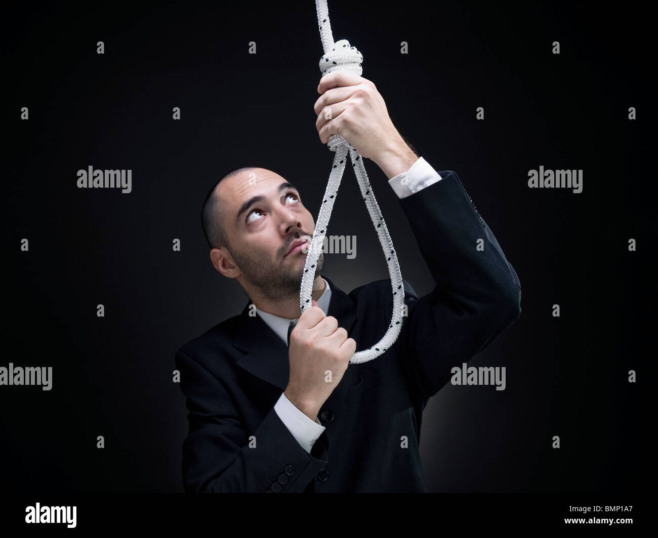 A businessman is setting up a noose. Stock Photo