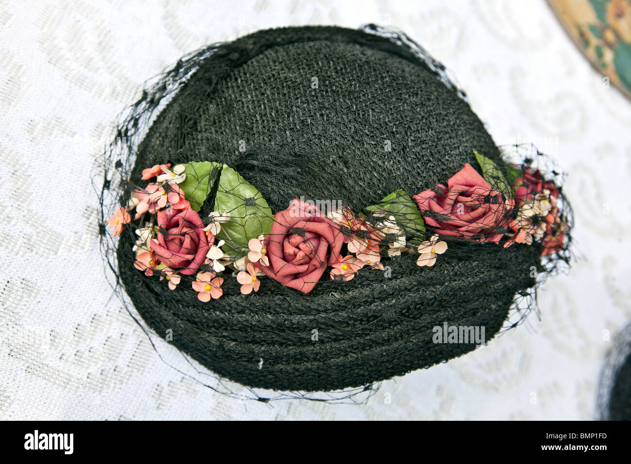 antique ladies hat trimmed with roses & veil displayed for sale at westside Manhattan block annual flea market New York city Stock Photo