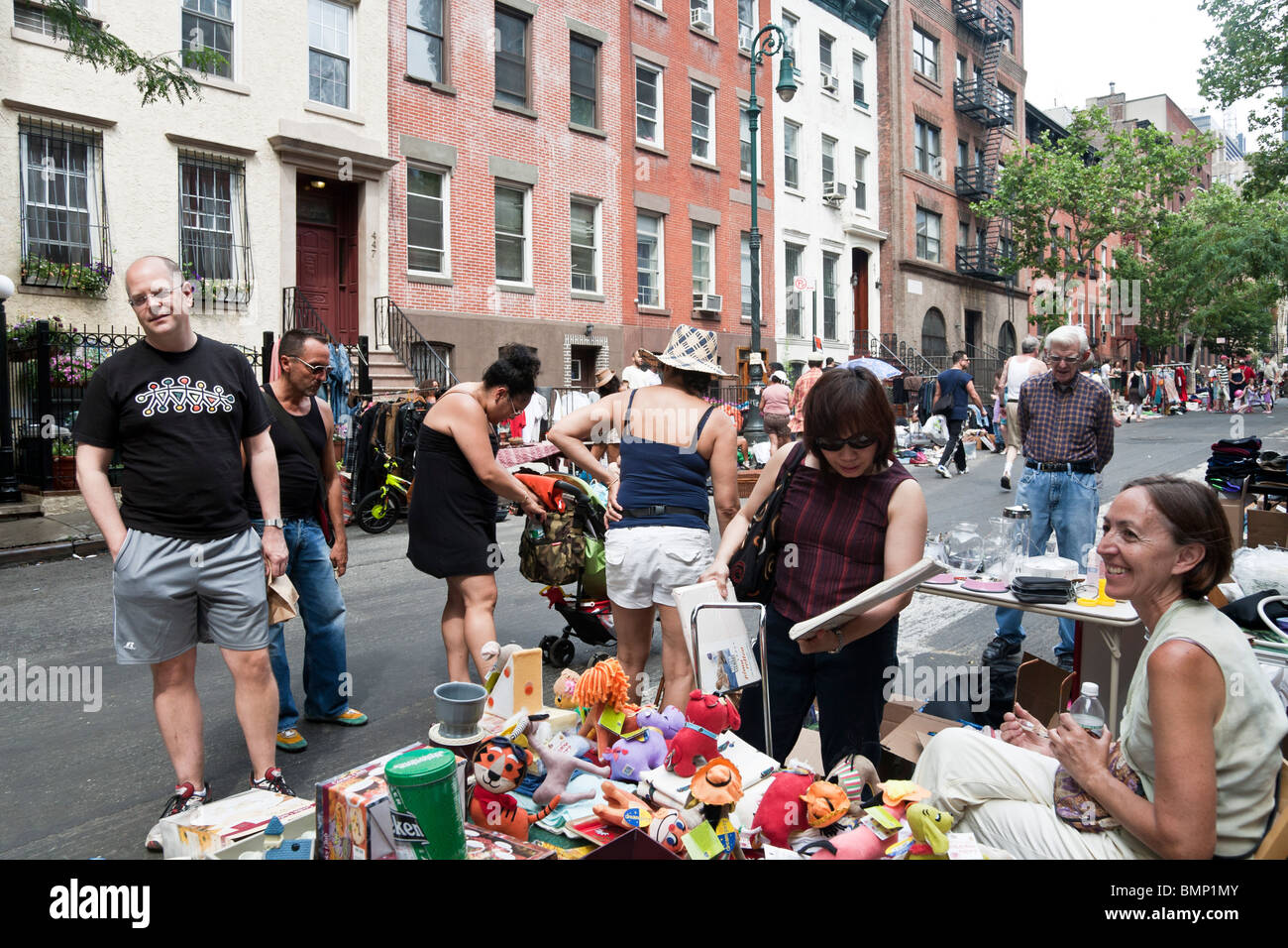 neighborhood crowd of New Yorkers browses treasures at west side Manhattan block annual flea market New York City Stock Photo