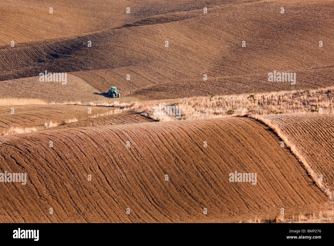 Malaga, Spain; Green Tractor Ploughing Fields Near Alhaurin El Grande Stock Photo