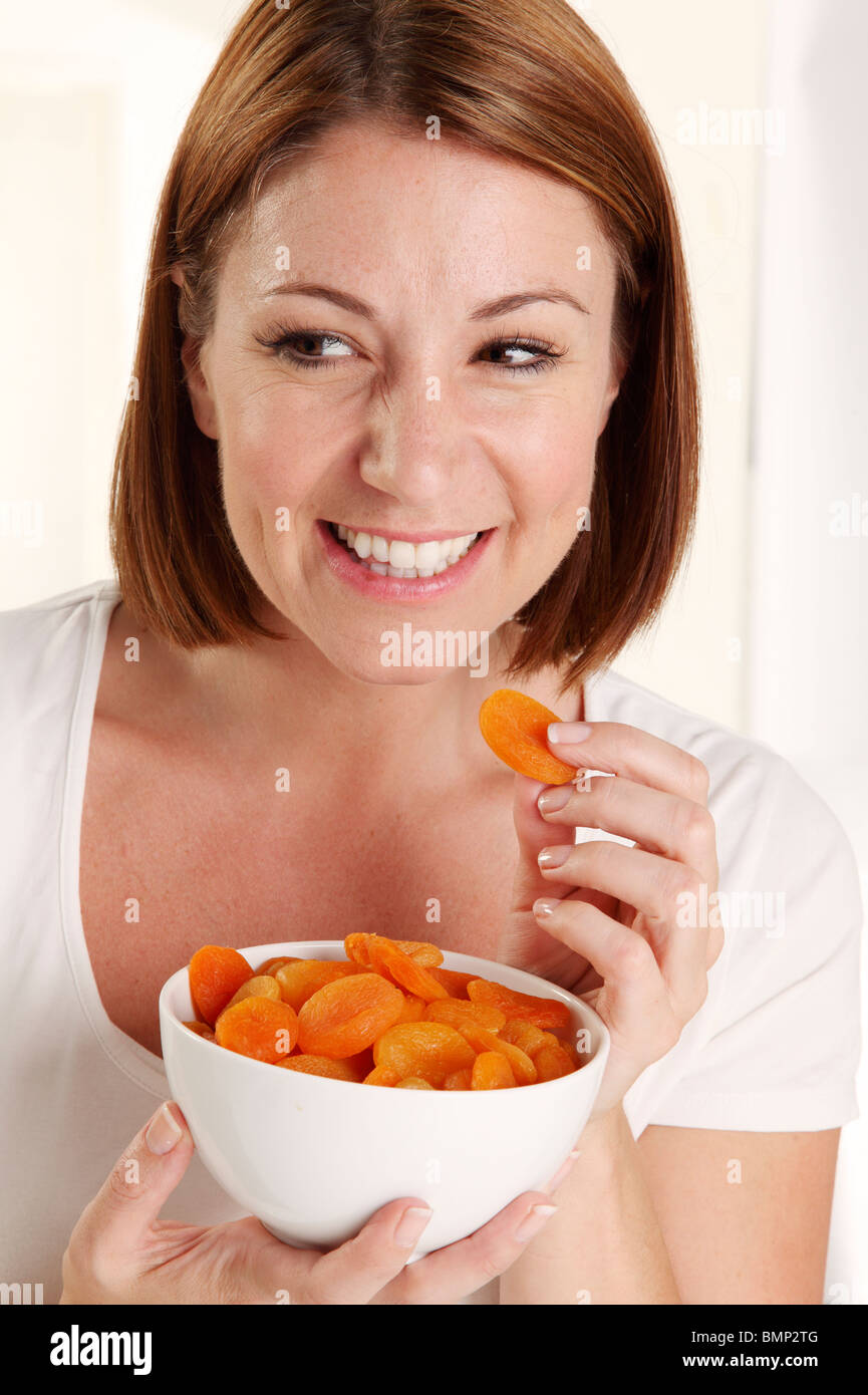 WOMAN EATING DRIED APRICOTS Stock Photo Alamy
