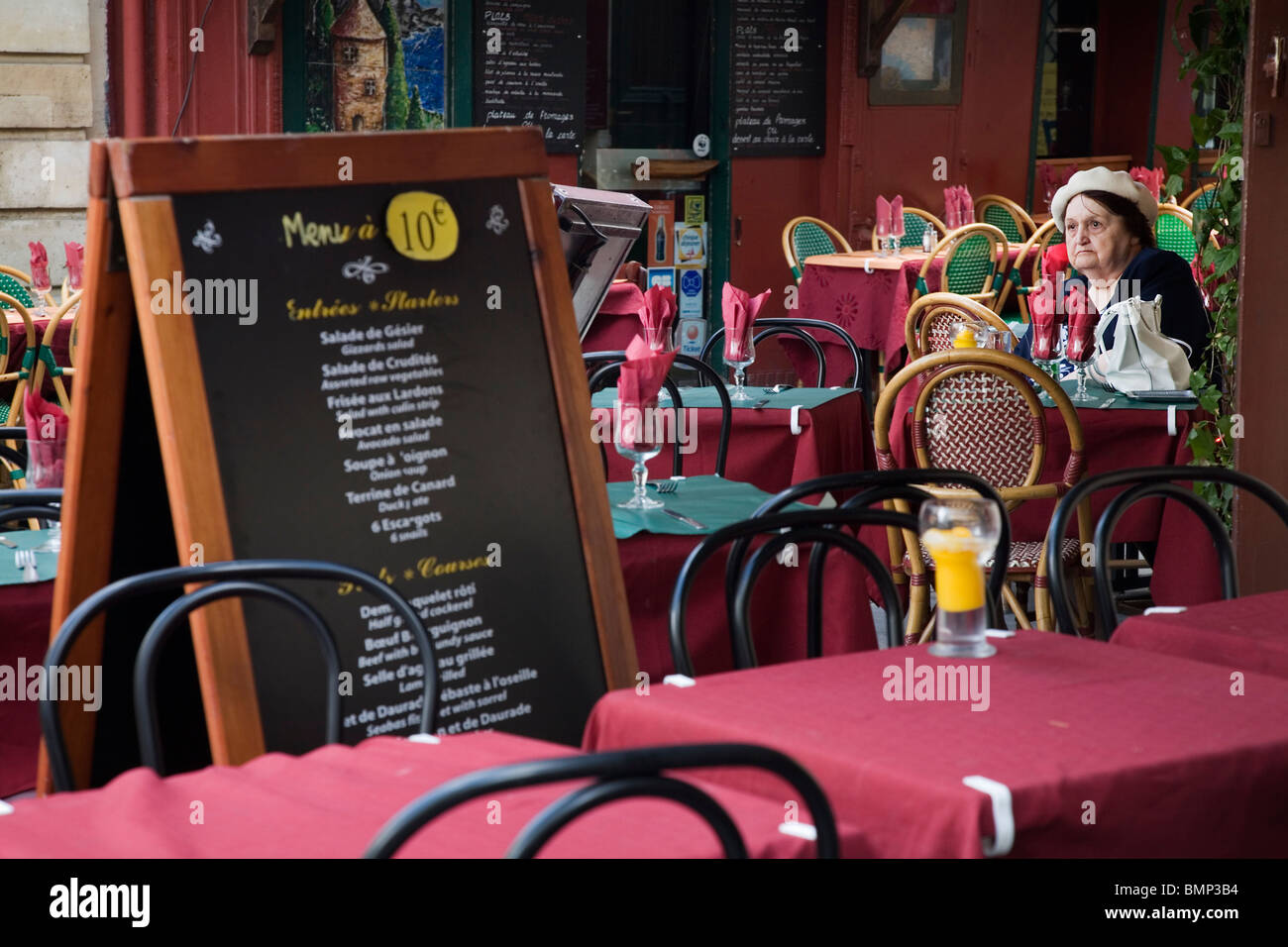 An old lady sitting in a cafe, Rue Mouffetard, Paris Stock Photo