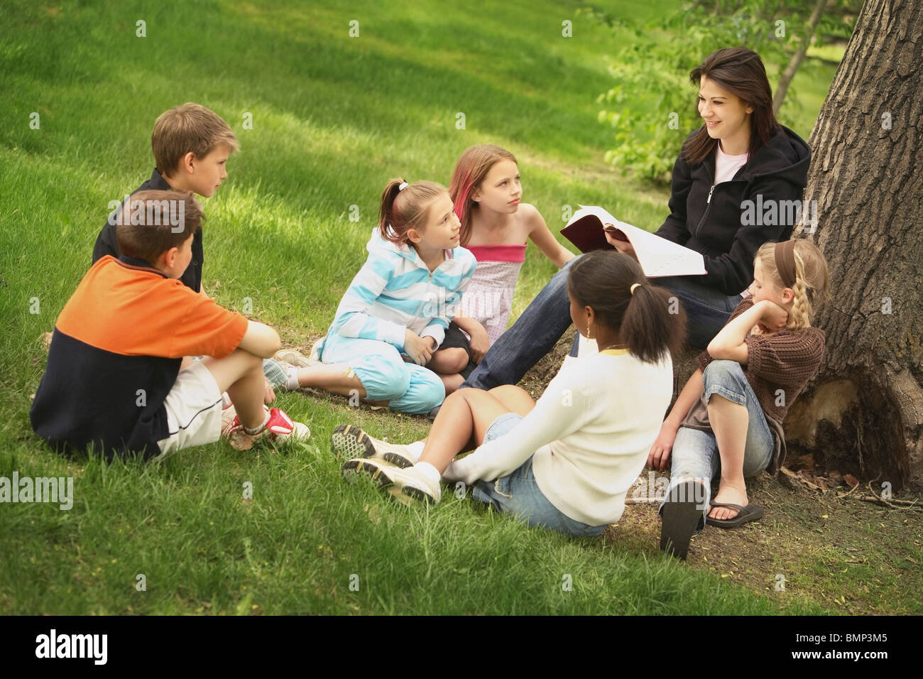 Edmonton, Alberta, Canada; A Woman Teaches A Group Of Children In A Park Stock Photo