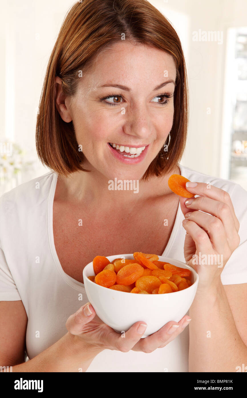 WOMAN EATING DRIED APRICOTS Stock Photo Alamy