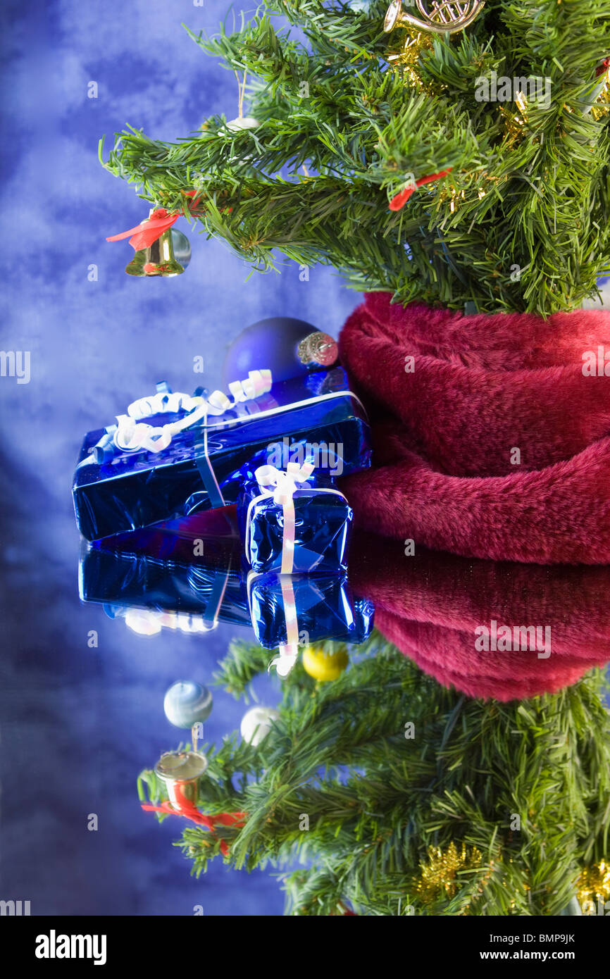 Chriistmas tree with blue foil wrapped presents, reflections, and copyspace Stock Photo