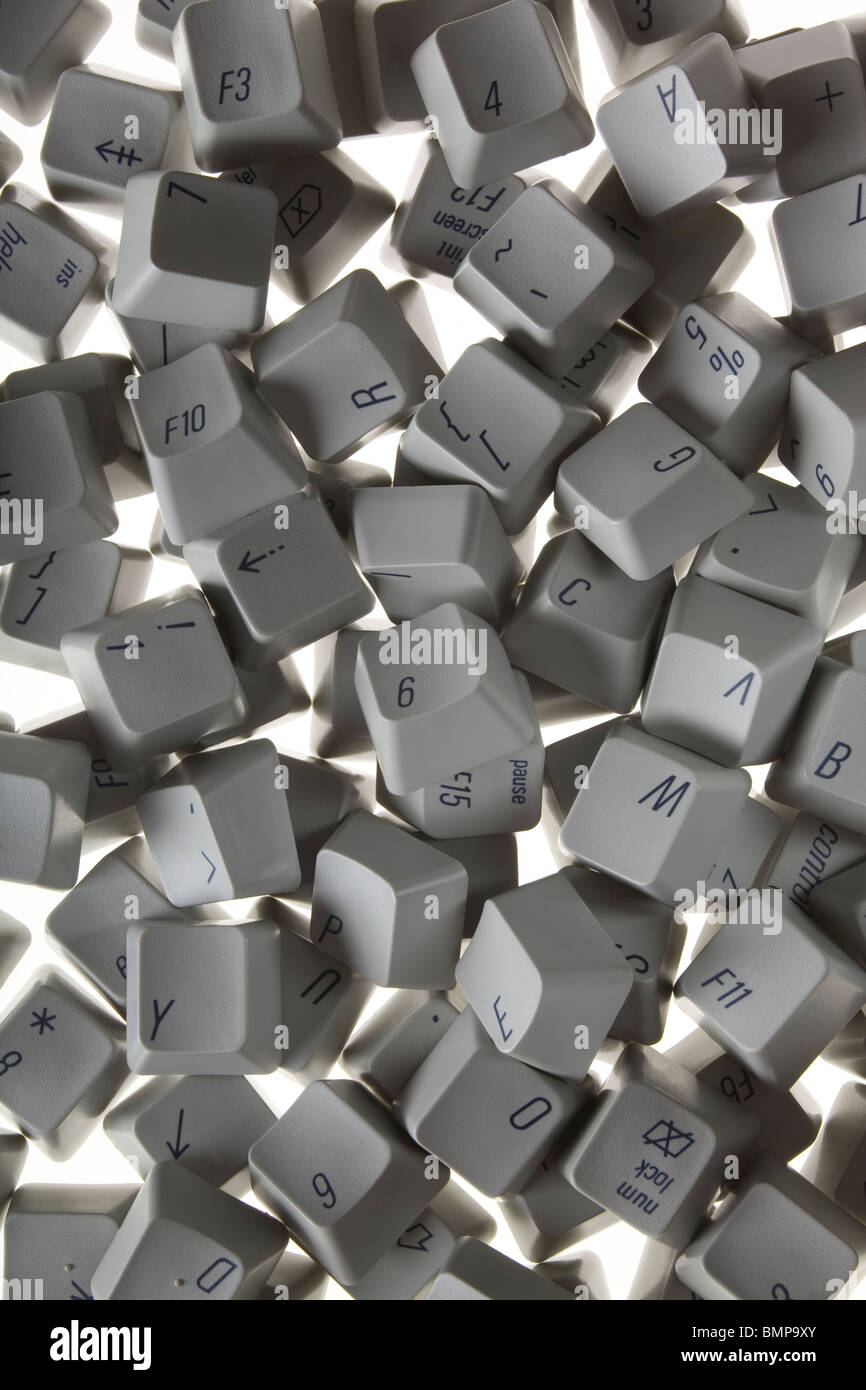 A photograph from above of old computer keyboard keys scattered randomly. Stock Photo