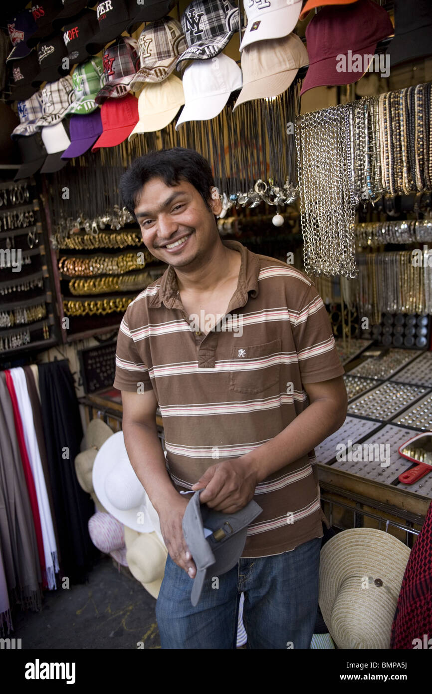 Bangladeshi immigrant selling hats at a kiosk on St. Mark's Place in the East Village in New York City. Stock Photo