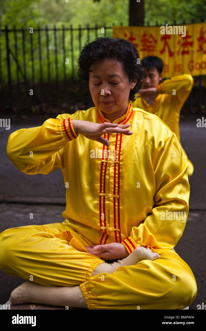 Woman practising Falun Gong, a form of Chinese meditation exercises in a position known as 'reinforcing Supernatural Powers'. Glasgow, Scotland Stock Photo
