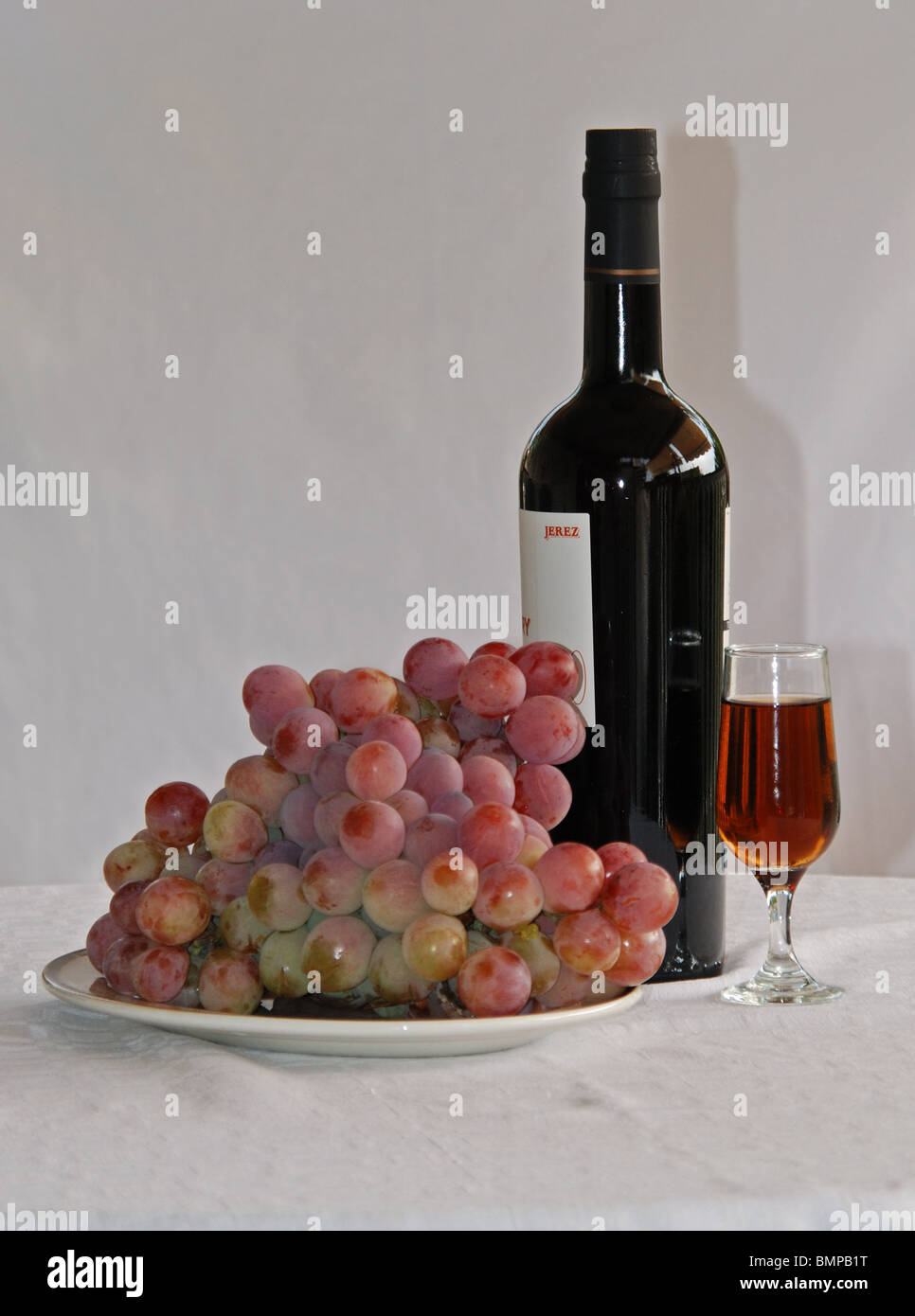 Sherry bottle, glass of sherry and red grapes, Costa del Sol, Malaga Province, Andalucia, Spain, Western Europe. Stock Photo