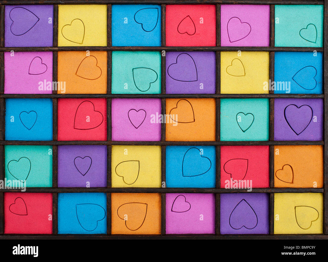 Multicoloured heart shape grid pattern in a wooden tray Stock Photo