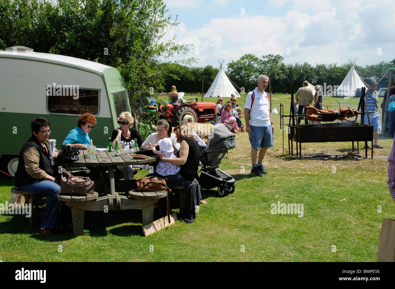 Hog roast on the spit at a midsummer country fair in Kent England UK Stock Photo