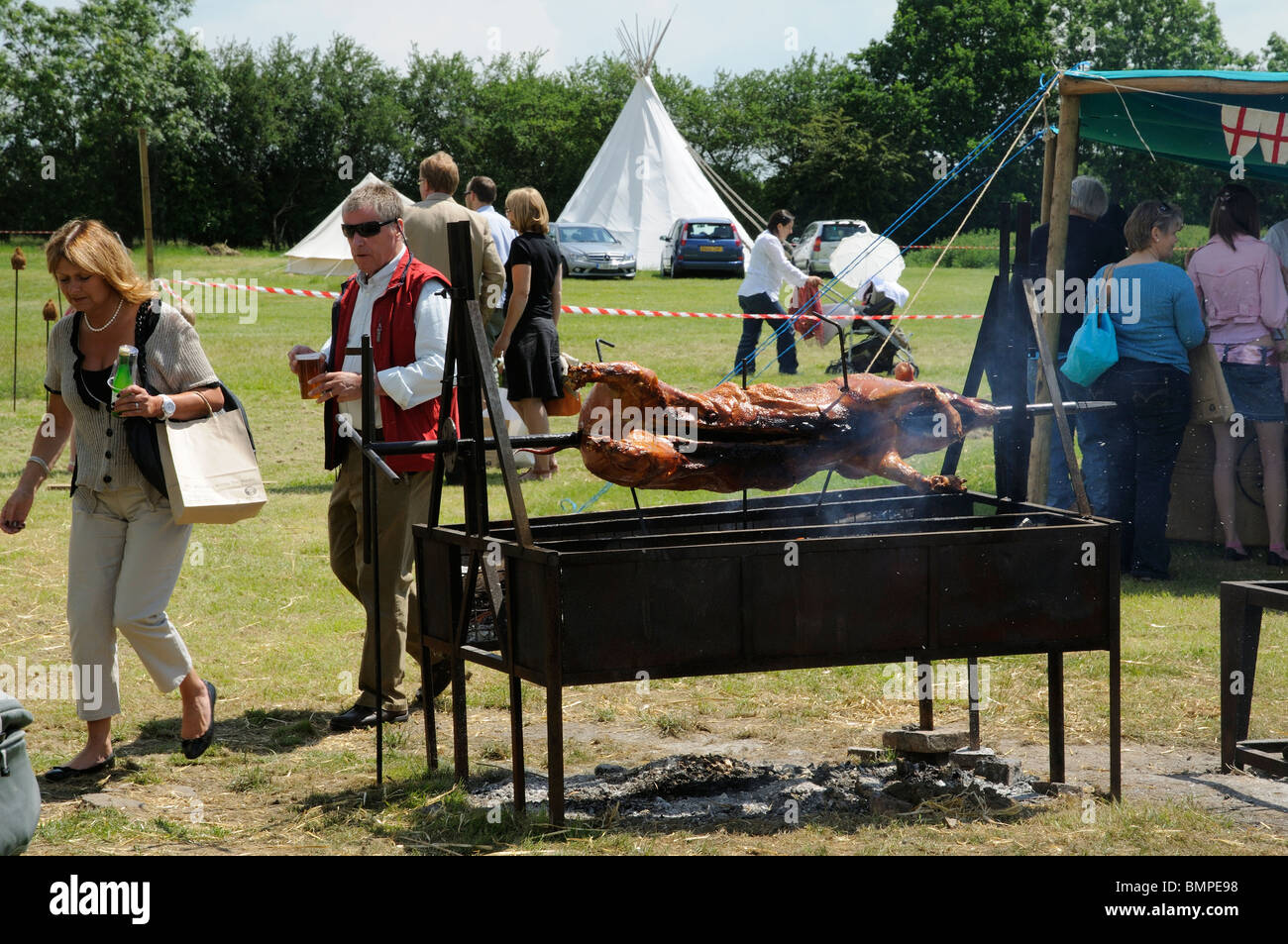 Hog roast on the spit at a midsummer country fair in Kent England UK Stock Photo